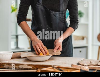 Close-Up Of Woman's Hands Making Clay Plate In Ceramics Workshop Stock Photo