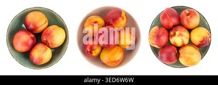 Large collection  overhead views of ripe nectarines and peaches served in various colorful ceramic plates and bowls. Vibrant red and yellow stone frui Stock Photo