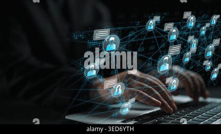 Hands of a businessman interacting with digital holographic network of people, symbols, and connections in a technological workspace environment Stock Photo