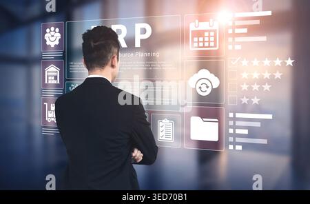 A businessman stands in a modern office, engaging with a digital ERP dashboard filled with various business tools and metrics, showcasing the future Stock Photo