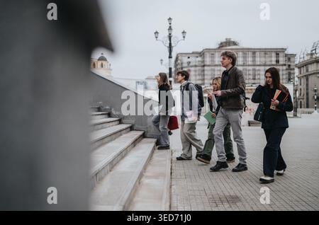 High school students walking up city steps together carrying books and backpacks Stock Photo