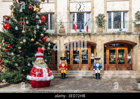 Le Lavandou, France - December 8, 2025: Town hall decorated for Christmas with festive tree, nutcracker figures and Santa Claus sculpture in front of Stock Photo