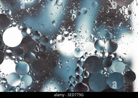 Oil with water round different sizes bubbles in blue and dark grey tones blur effect macro Stock Photo