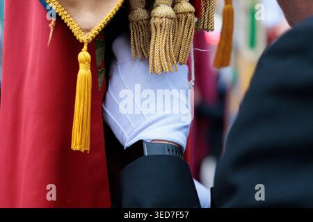 Detail of Hand with White Glove Holding an Ornamental Flag with Golden Tassels Stock Photo