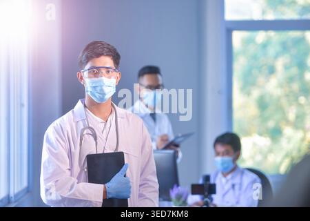 Portrait of three doctors wearing face masks in a hospital office Stock Photo