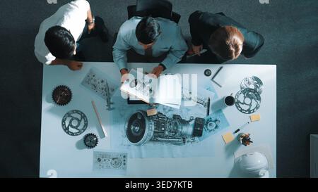 Top down view of skilled engineer working together while looking at jet engine. Aerial view of smart designer or diverse technicians brainstorming Stock Photo