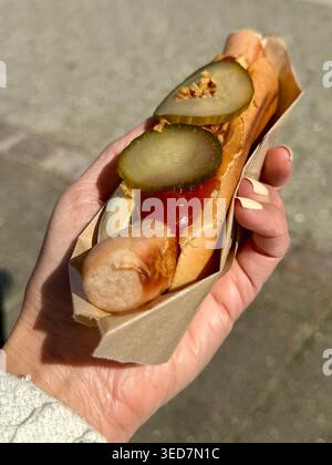 Close-up of a woman standing outdoors holding a traditional Danish hotdog Stock Photo