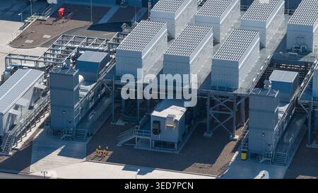Aerial view of Datacenter Westpoort featuring cooling units, metal structures, and solar panels on a clear day in Groningen, Groningen, Netherlands. Stock Photo