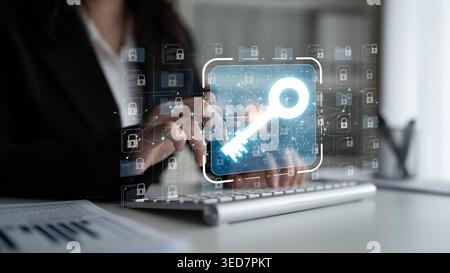 Business professional using digital technology for cybersecurity with virtual key symbol overlay on computer screen representing encryption and data Stock Photo