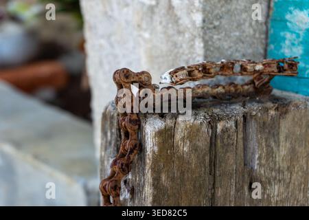 A high-resolution macro photograph showing the detailed texture of an old, weathered, and rusty metal chain. The close-up captures the rough surface, Stock Photo