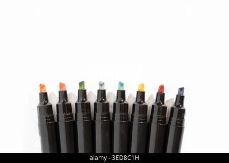 Colorful markers arranged in a neat row on a white background with copy space Stock Photo