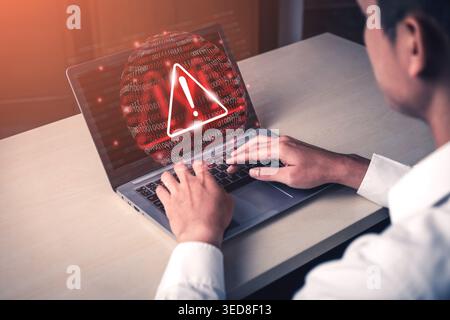 A focused individual interacts with a laptop, highlighting a warning sign on the screen, symbolizing urgent cybersecurity issues and the need for Stock Photo