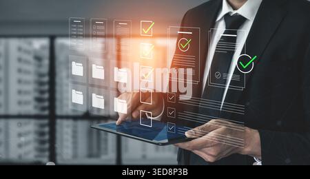 A businessman interacts with a tablet, utilizing digital tools and checklists for effective document management and enhanced productivity in a modern Stock Photo
