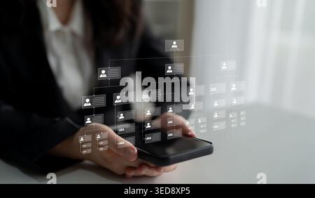 A person interacts with a smartphone displaying a digital interface that illustrates user profiles and social connections, representing modern Stock Photo