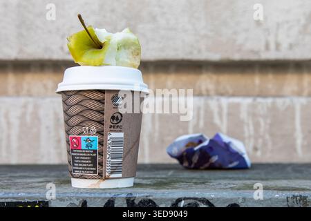 Apple core, disposable coffee cup and snack wrapper left behind on a utility cabinet in Helsinki, Finland Stock Photo