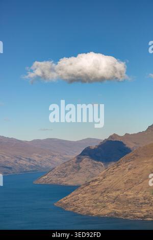 A single cumulus cloud above Lake Wakatipu Queenstown, Otago, New Zealand Stock Photo