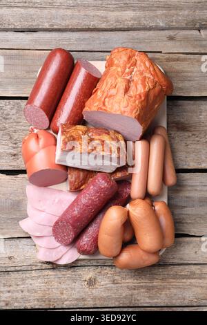 Different types of sausages and cured meat on wooden table, top view Stock Photo