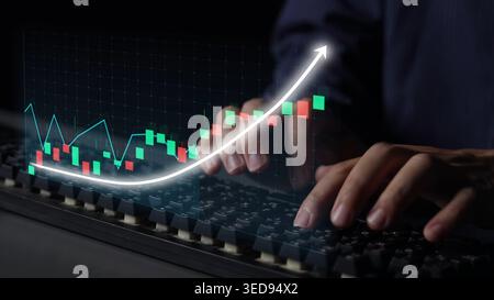A close-up view of hands typing on a keyboard while an upward-trending stock market graph is displayed, symbolizing financial growth and investment Stock Photo
