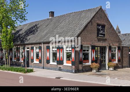 Zeist, Netherlands, April 28, 2026. A charming historic brick shop named My Home featuring traditional Dutch red and white diagonal shutters and a til Stock Photo
