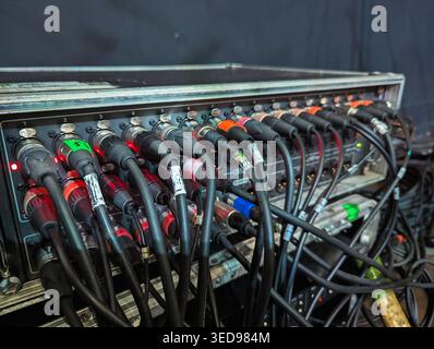 A complex array of colorful cables intricately connected to a professional audio mixer in a recording studio. Stock Photo