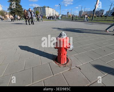 Lviv, Ukraine, May 2, 2026: Bright Red Fire Hydrant Standing Proudly on a Weathered Brick Sidewalk in an Urban Environment Stock Photo