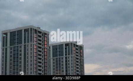 Two modern, beautifully designed high-rise buildings, part of a residential complex, blend into the urban landscape, two high-rise buildings Stock Photo