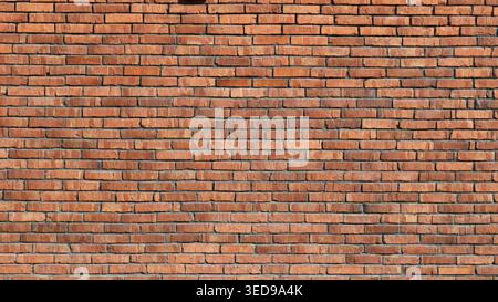 A detail of a red textured brick wall, rendered in bright sunlight, with old, weathered brickwork as a backdrop, and a crumbling brick facade or wall Stock Photo
