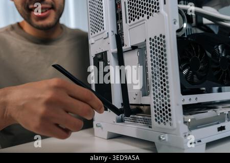 Cropped shot of male installing wireless network adapter antenna into personal computer, providing faster internet connection and enhancing data Stock Photo