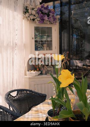 Yellow tulips on a table in vintage cafe Ott and Matilda Kohvik with dried flowers and antique cabinet, Tallinn, Estonia Stock Photo