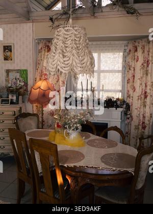 Vintage dining table with lace tablecloth and wildflowers in Ott and Matilda Kohvik cafe, Estonia Stock Photo