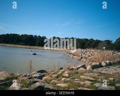 Rocky shoreline with boulders and calm Baltic Sea waters at Lohusalu beach, Estonia, on a clear spring day Stock Photo