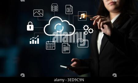 A businesswoman engages with cloud technology icons representing data storage and digital solutions in a modern workplace, showcasing innovation and Stock Photo