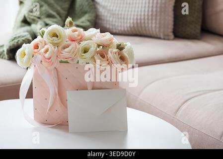 Delicate lifestyle composition featuring a quilted pink gift bag filled with cream and blush ranunculus flowers, accented by ribbon handles and decora Stock Photo