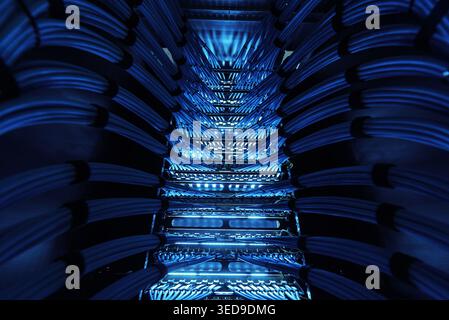 A striking view of network cables illuminated by vibrant blue lights, showcasing modern technology and connections in a server environment. Stock Photo