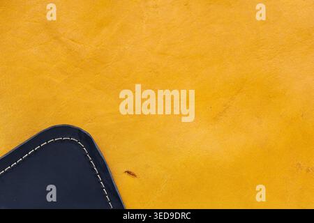 Yellow Leather Surface Texture Background with Navy Blue Stitched Leather Corner Detail Stock Photo