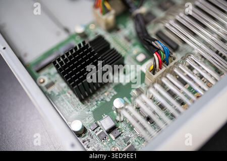 Detailed close-up of electronic circuitry showcasing components like processors and cooling systems essential for modern technological devices. Stock Photo
