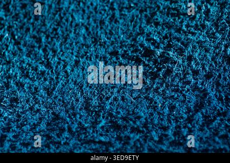 Background with rough dark navy blue leather texture, natural fiber detail in the foreground. Stock Photo