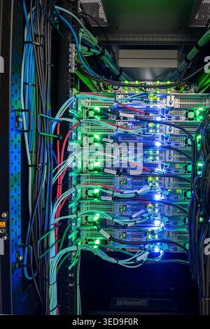 A modern server rack filled with advanced technology and colorful lights. This image showcases the intricate cabling and hardware in a data center env Stock Photo