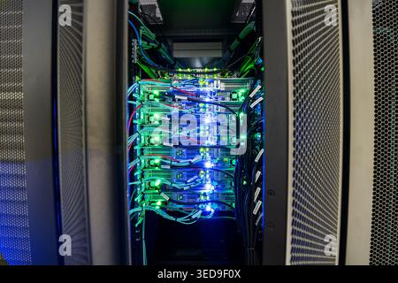 This image showcases a modern data center server rack with illuminated components and organized cables, highlighting advanced technology in digital in Stock Photo