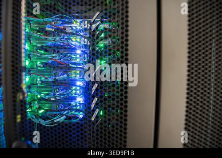 This image showcases a high-tech data center filled with illuminated servers and intricate cable connections, representing modern digital infrastructu Stock Photo