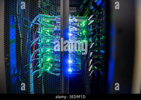 A detailed view of a server room showcasing organized cables and illuminated server racks, highlighting technology and connectivity in modern infrastr Stock Photo