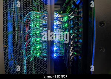 A detailed view of a server room showcasing intricate connections and vibrant LED lights, illustrating the inner workings of modern data technology an Stock Photo