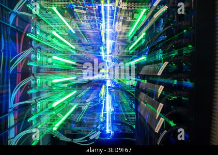 This image showcases a vibrant display of lights and cables in a server rack, illustrating the dynamic nature of technology in data communication and Stock Photo