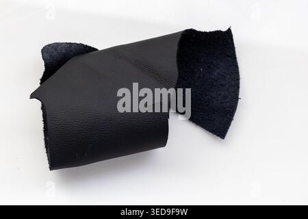 Folded Black Leather Piece Revealing Dark Suede Interior on White Background, Raw Genuine Material Close-Up Stock Photo
