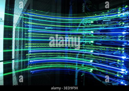 A captivating image of a data center showcasing vibrant light trails of green and blue. This abstract representation highlights technology, energy flo Stock Photo