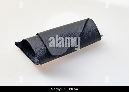 Folded Black Leather Piece Revealing Dark Suede Interior on White Background, Raw Genuine Material Close-Up Stock Photo