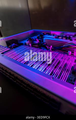 This striking image showcases a close-up view of modern computing hardware illuminated with vibrant blue and purple lights, highlighting intricate cir Stock Photo