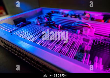 A close-up view of a circuit board illuminated by neon lights, showcasing intricate details and vibrant colors. Perfect for technology and innovation Stock Photo