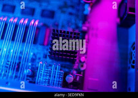 This image showcases an abstract close-up of a circuit board, featuring vibrant blue and purple lighting, highlighting the intricate details of electr Stock Photo