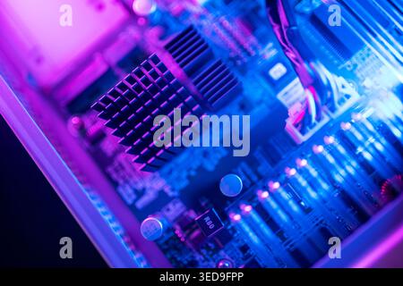 A vibrant close-up image of a computer circuit board showcasing intricate electronic components and colorful lighting, perfect for technology and desi Stock Photo